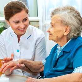 caregiver putting cream on her patient's hand