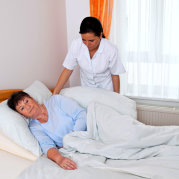 caregiver putting her patient to bed
