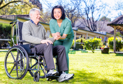 caregiver holding her patients hands on a wheelchair