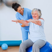 caregiver helping a senior woman exercise